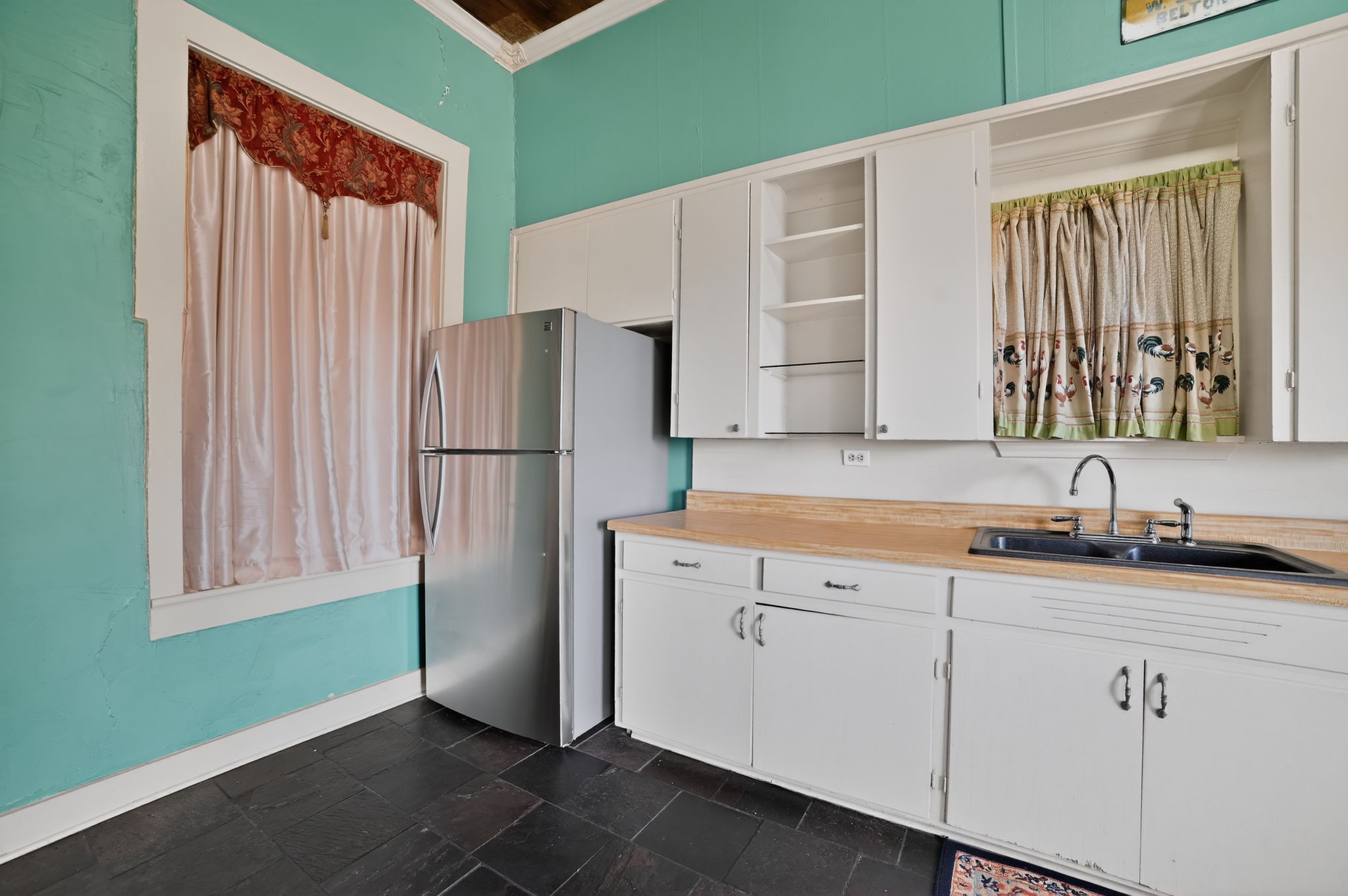 400 South Main Street Belton, TX 76513 - Photo 8 of 18 Kitchen featuring white cabinets, light countertops, open shelves, stone tile floors, and ornamental molding