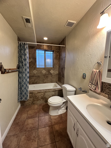 140 North 200 E Street Glenwood, UT 84730 - Photo 30 of 54 Full bathroom with a textured wall, vanity, a textured ceiling, and tiled shower / bath combo