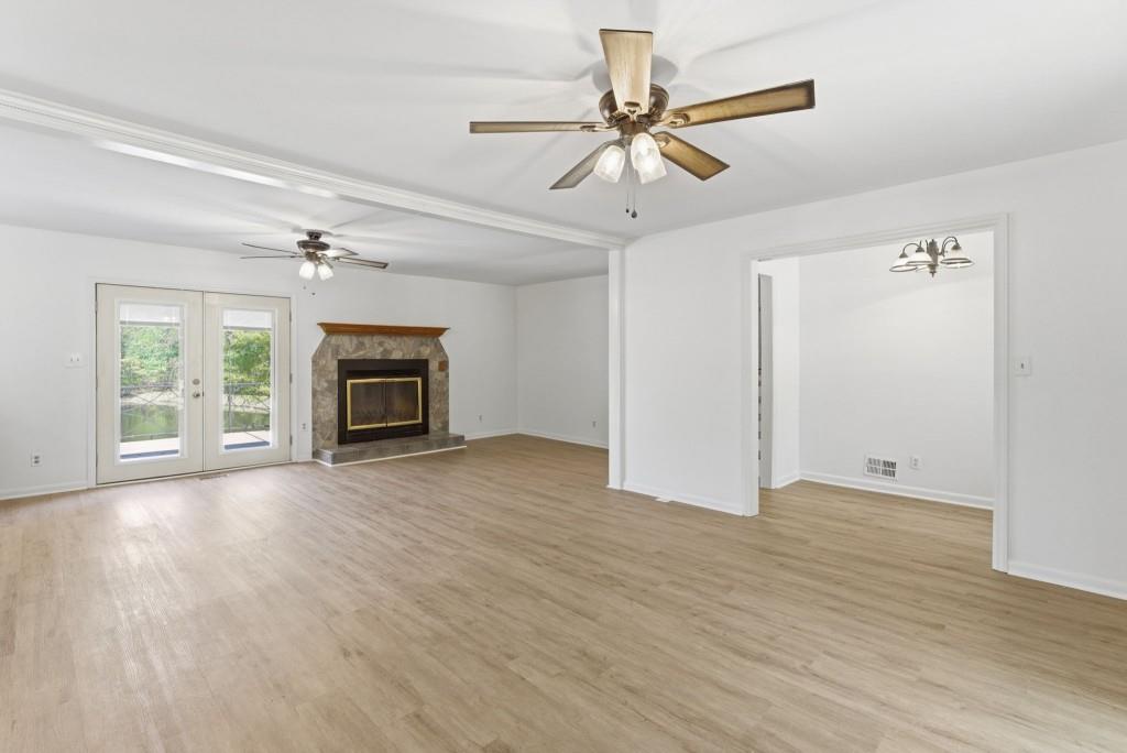 224 Old Franklin Street Roopville, GA 30170 - Photo 6 of 60 an empty room with wooden floor ceiling fan and windows