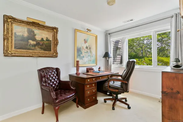 a view of a workspace with furniture and a window