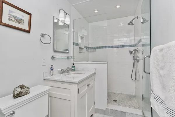 a bathroom with a sink vanity granite shower and a mirror