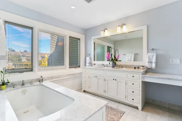a bathroom with a tub sink and mirror