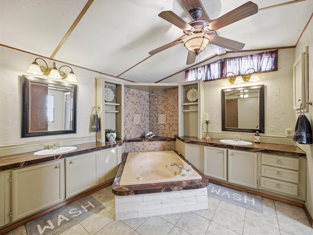 196 Perch Road Bowie, TX 76230 - Photo 13 of 33 a spacious bathroom with a sink a large mirror and a bathtub