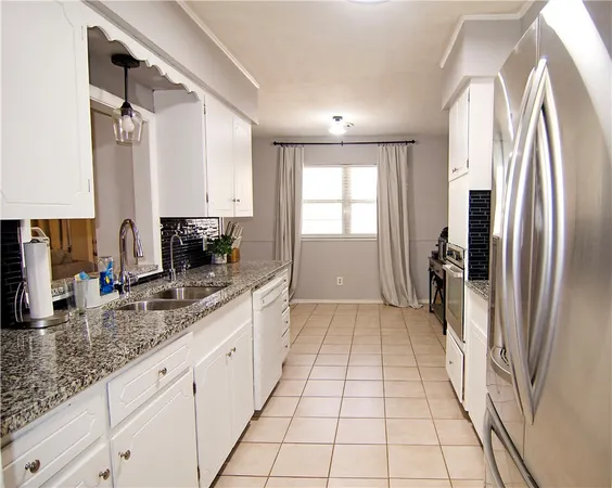 a kitchen with stainless steel appliances granite countertop a refrigerator and a sink
