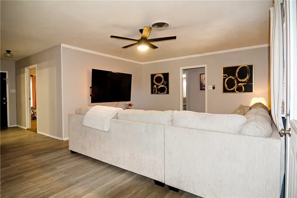 a living room with a bed furniture and a flat screen tv
