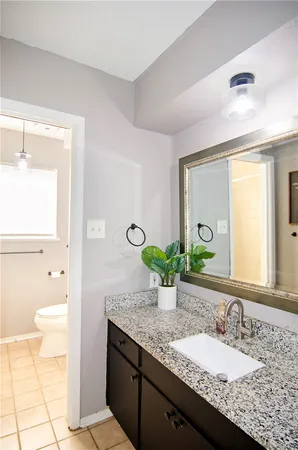 a bathroom with a granite countertop sink and a mirror