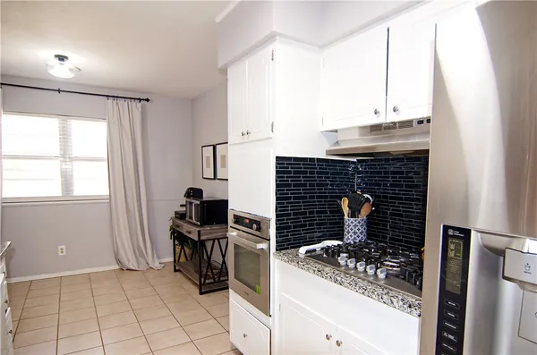 a kitchen with granite countertop a sink stove and cabinets