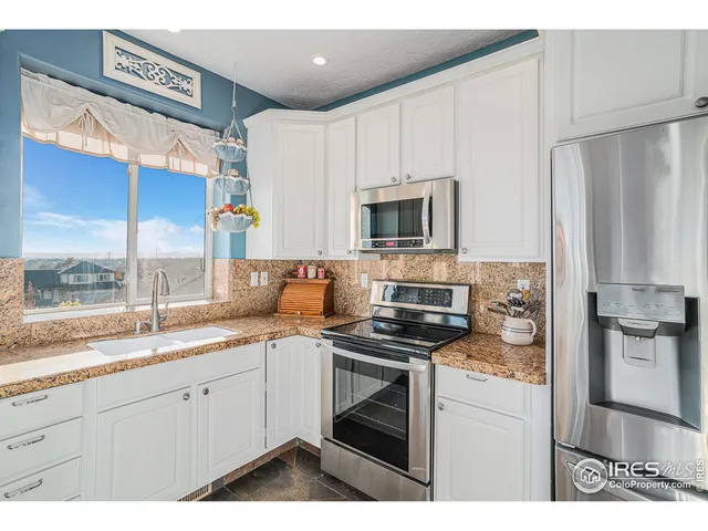 a kitchen with a sink appliances cabinets and a window