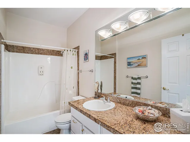a bathroom with a granite countertop sink a toilet and a mirror