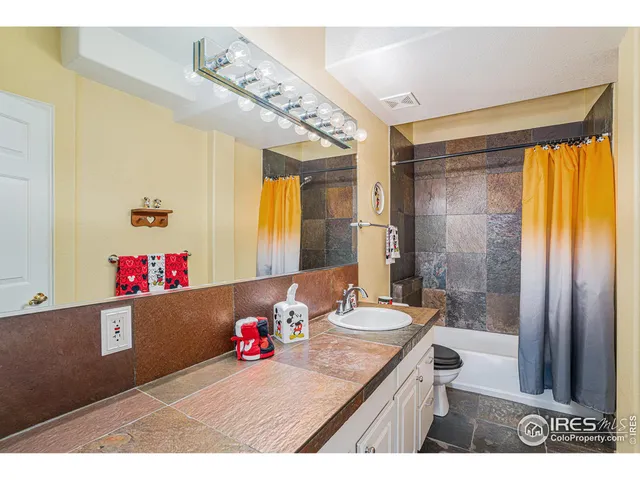 a bathroom with a granite countertop sink a shower and a mirror