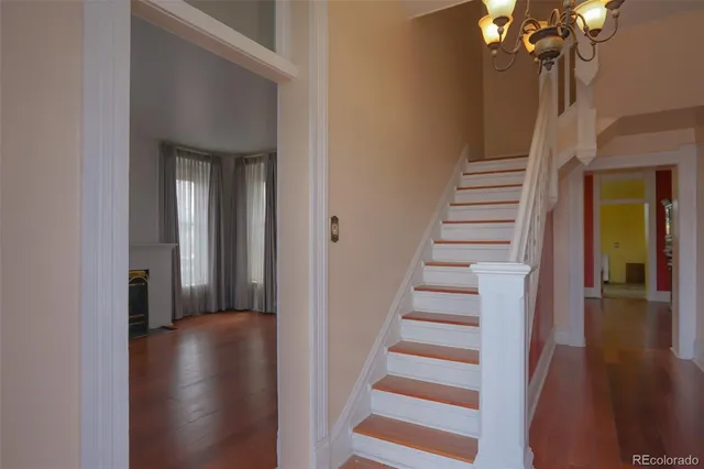 a view of a hallway with wooden floor and staircase