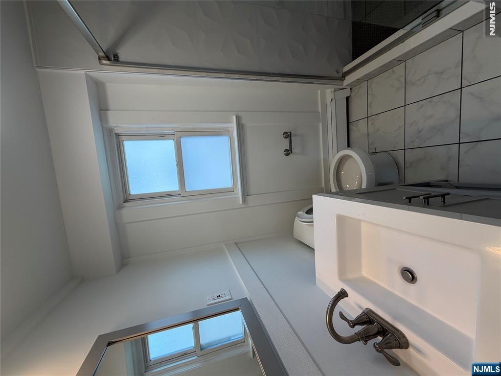 53 Devon Terrace, Unit 2 Kearny, NJ 07032 - Photo 11 of 15 a bathroom with a sink a toilet and shower