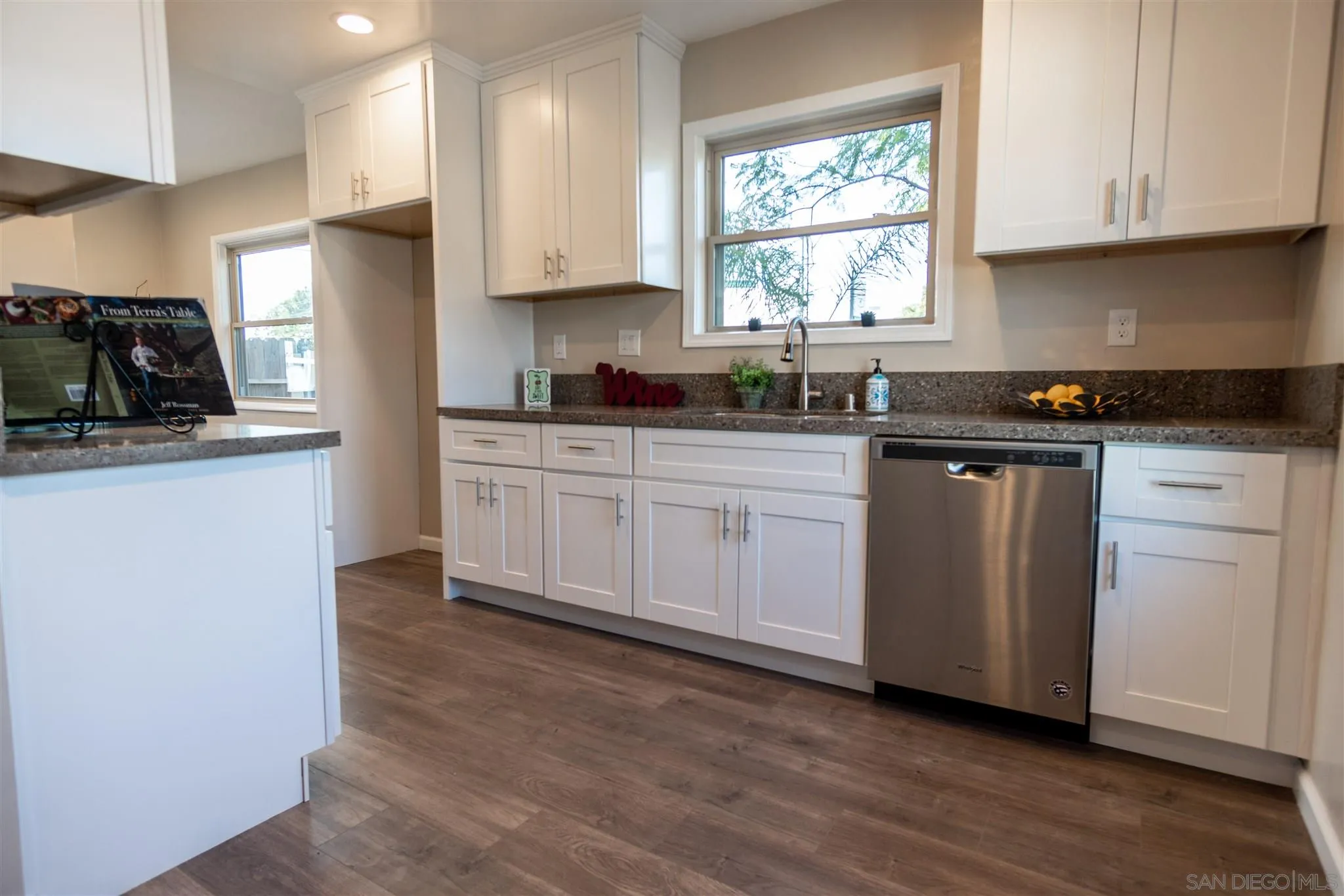 7204 Waite Drive La Mesa, CA 91941 - Photo 2 of 18 a kitchen with white cabinets appliances a sink and a window