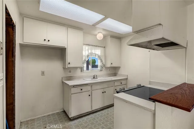 a kitchen with a sink dishwasher and white cabinets