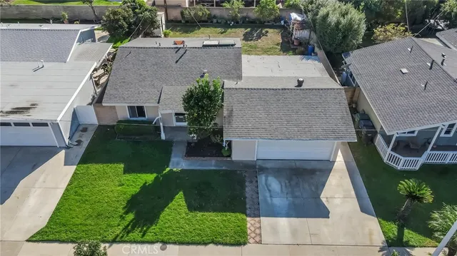 an aerial view of a house with garden space and a patio