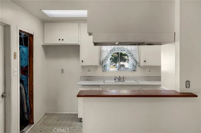 a view of kitchen island a sink a refrigerator and window