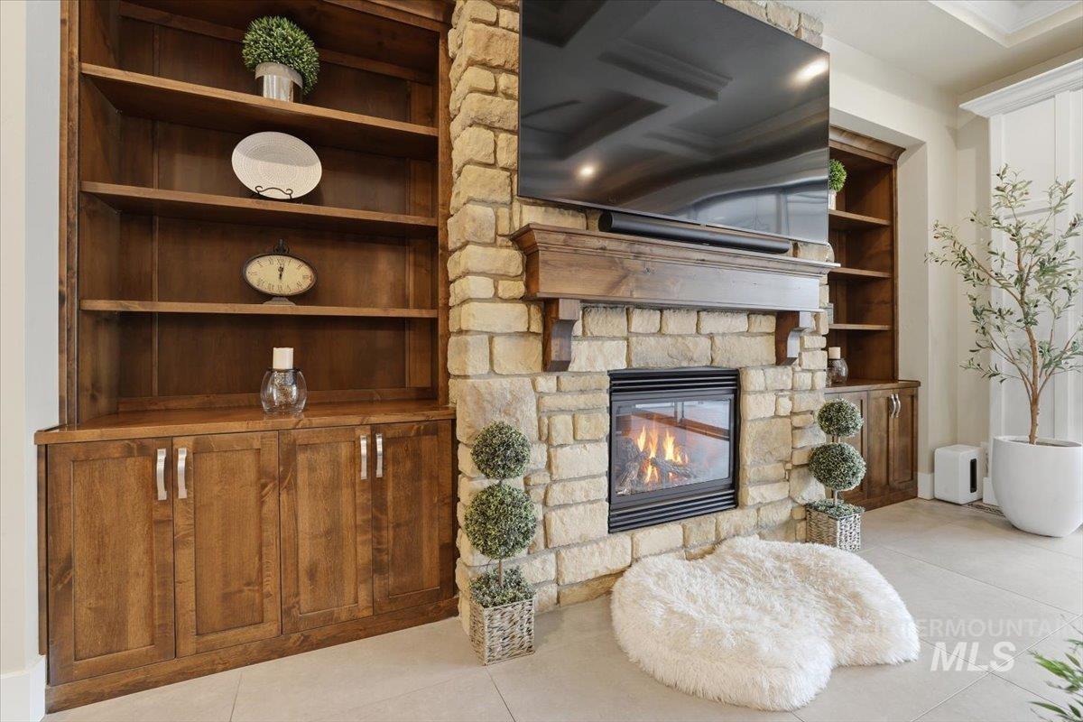 6590 North Fairborn Avenue Meridian, ID 83646 - Photo 14 of 49 Living area with a stone fireplace, light tile patterned floors, and built in features