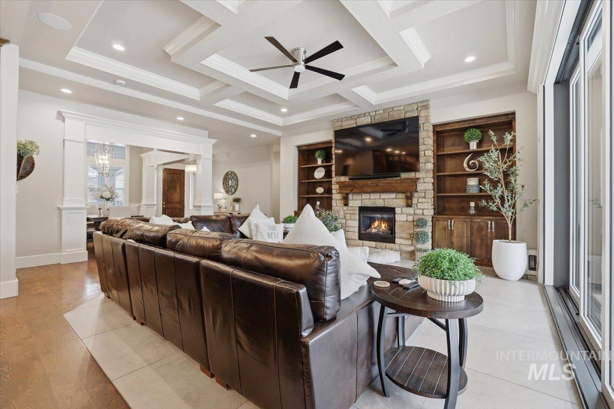 6590 North Fairborn Avenue Meridian, ID 83646 - Photo 15 of 49 Living area featuring ceiling fan, a fireplace, coffered ceiling, ornamental molding, and light wood-style flooring