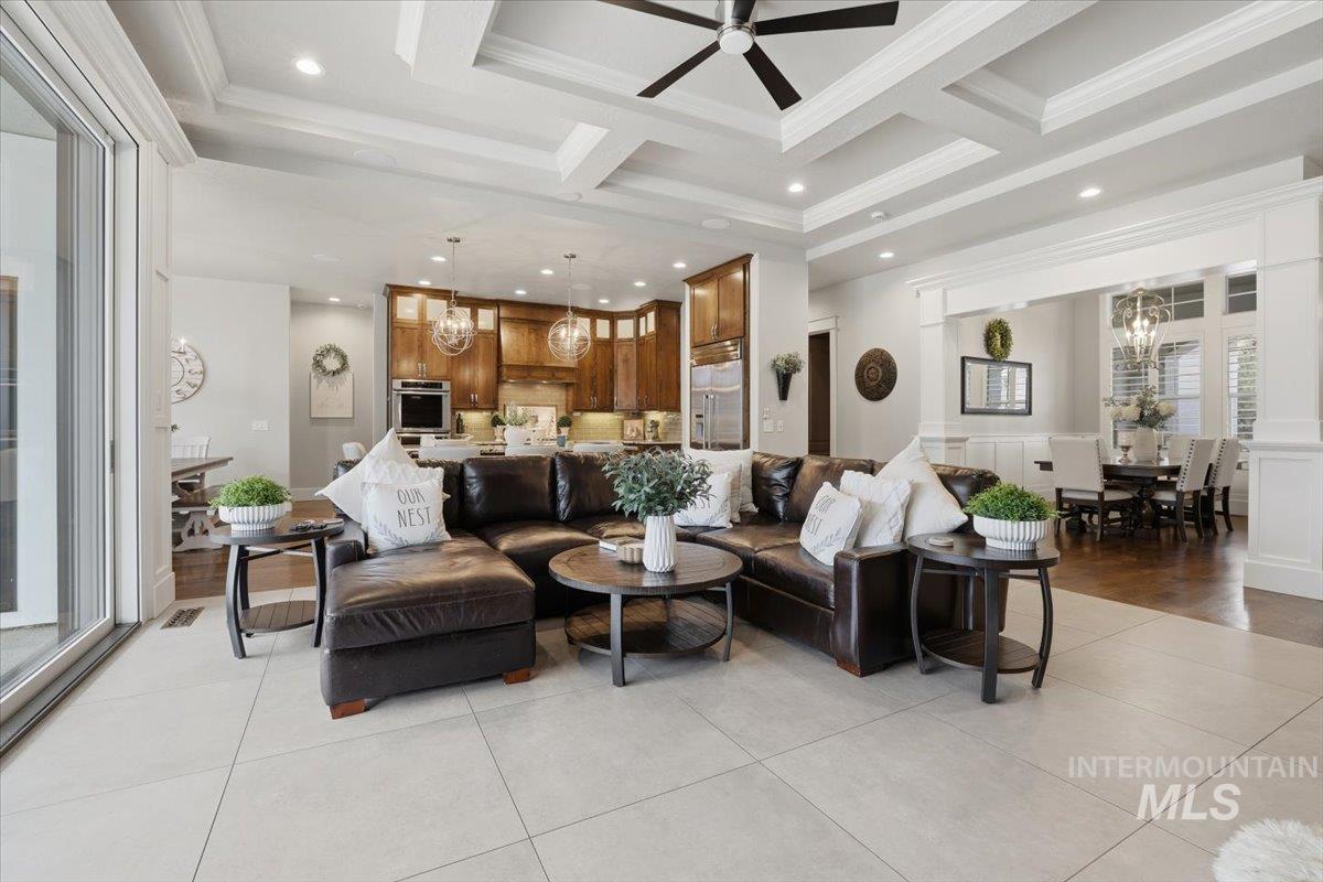 6590 North Fairborn Avenue Meridian, ID 83646 - Photo 17 of 49 Living area featuring a chandelier, crown molding, coffered ceiling, light tile patterned floors, and recessed lighting