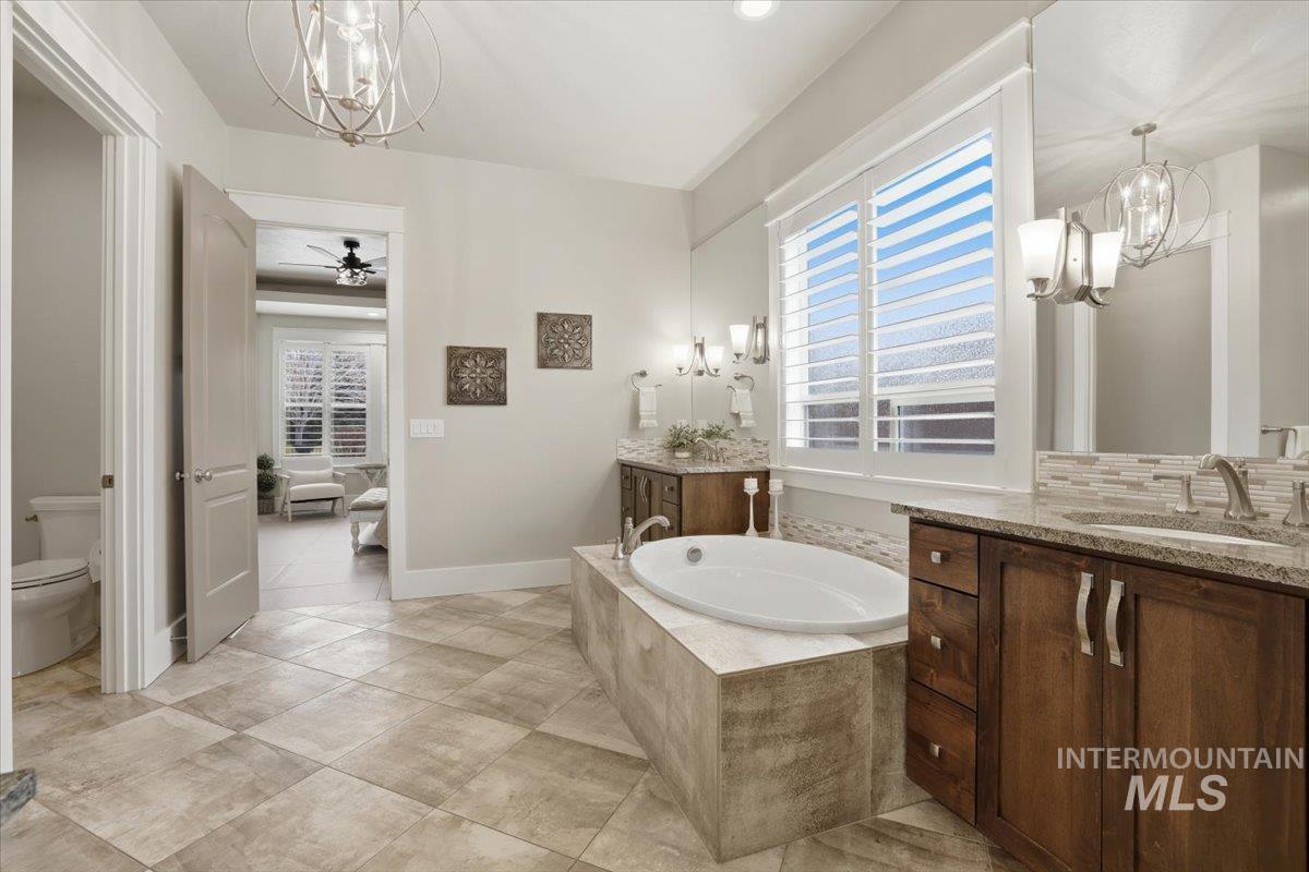 6590 North Fairborn Avenue Meridian, ID 83646 - Photo 29 of 49 Full bath featuring a chandelier, a garden tub, and two vanities