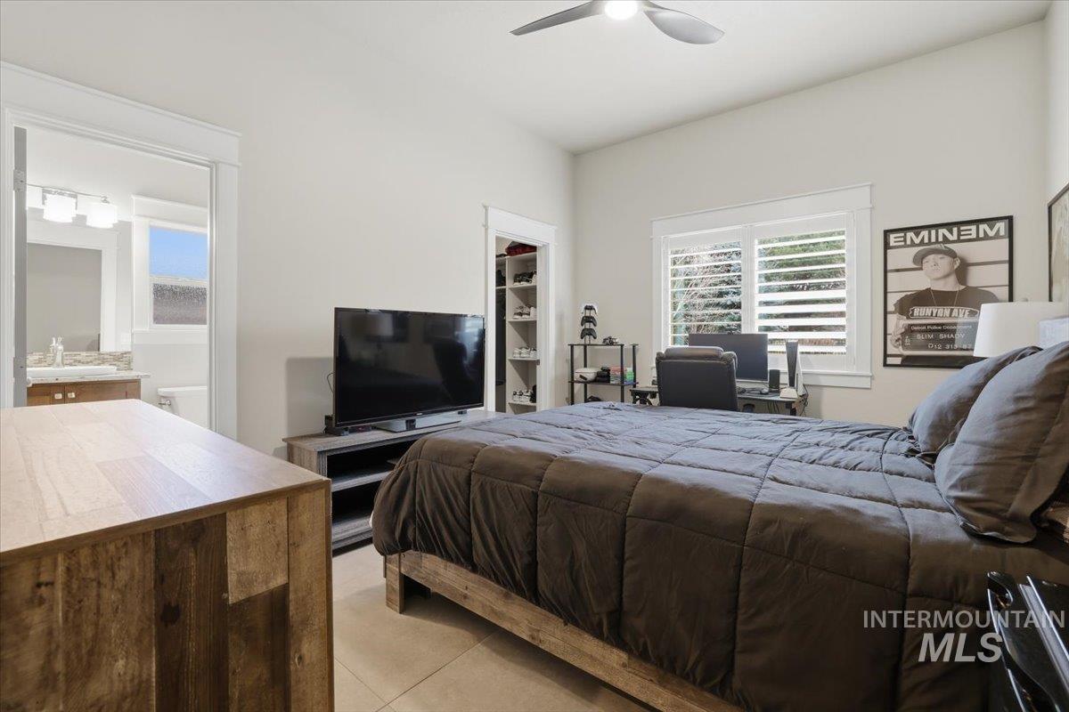 6590 North Fairborn Avenue Meridian, ID 83646 - Photo 34 of 49 Bedroom with a walk in closet, ceiling fan, and light tile patterned flooring