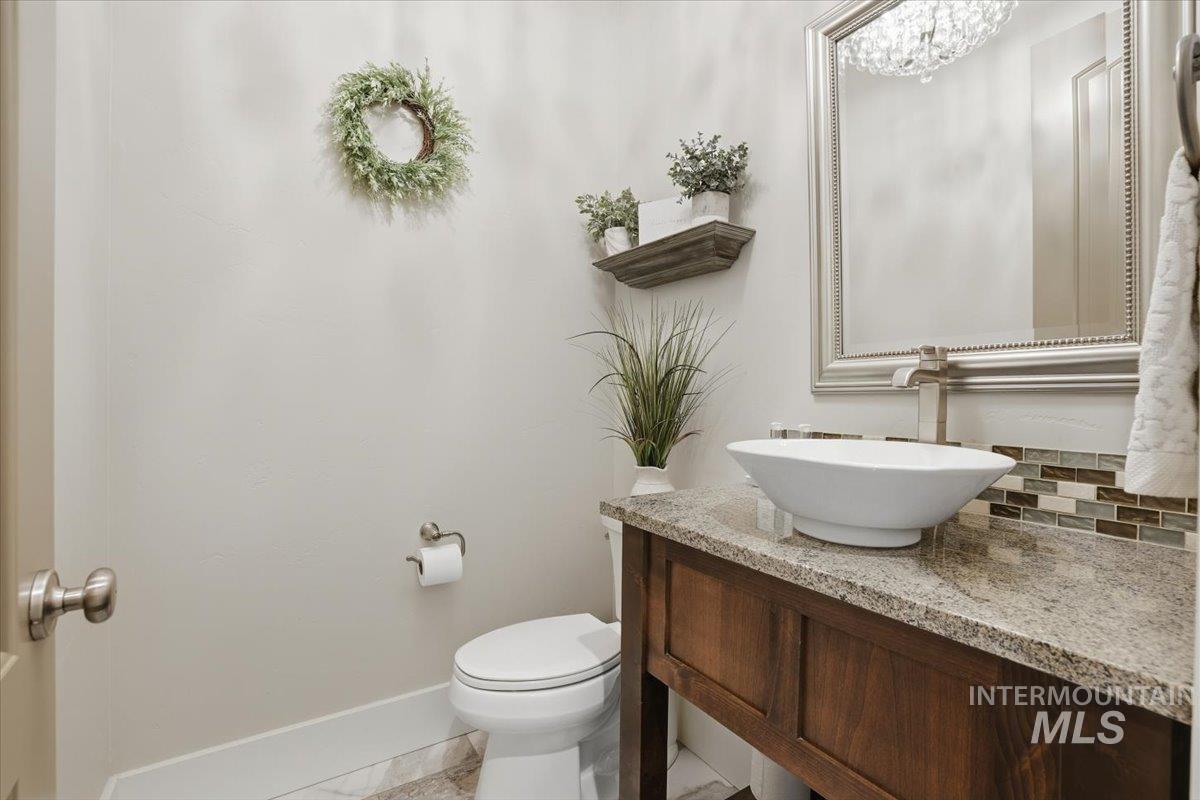 6590 North Fairborn Avenue Meridian, ID 83646 - Photo 36 of 49 Half bath featuring vanity and decorative backsplash