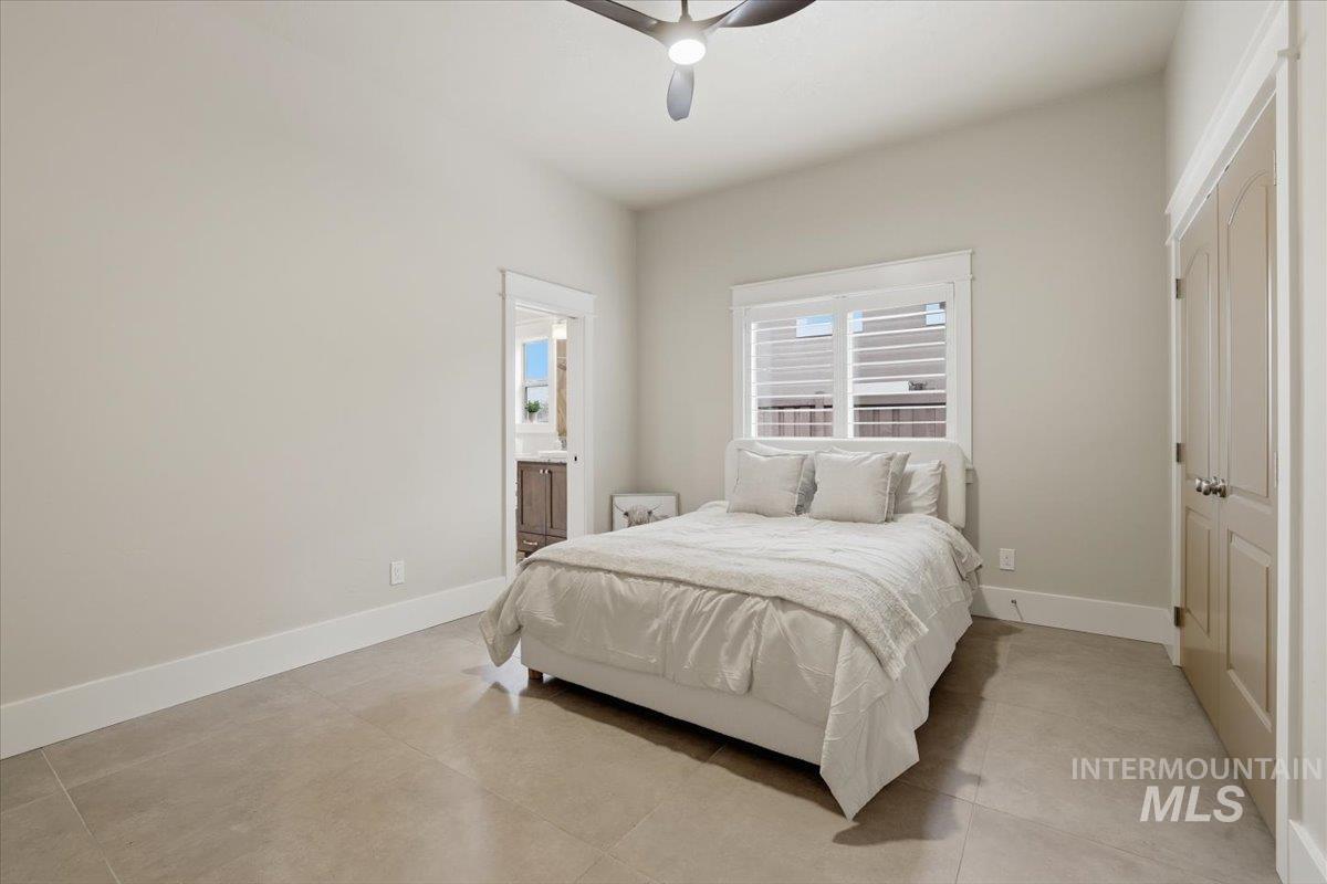 6590 North Fairborn Avenue Meridian, ID 83646 - Photo 37 of 49 Tiled bedroom featuring a closet, a ceiling fan, and ensuite bath