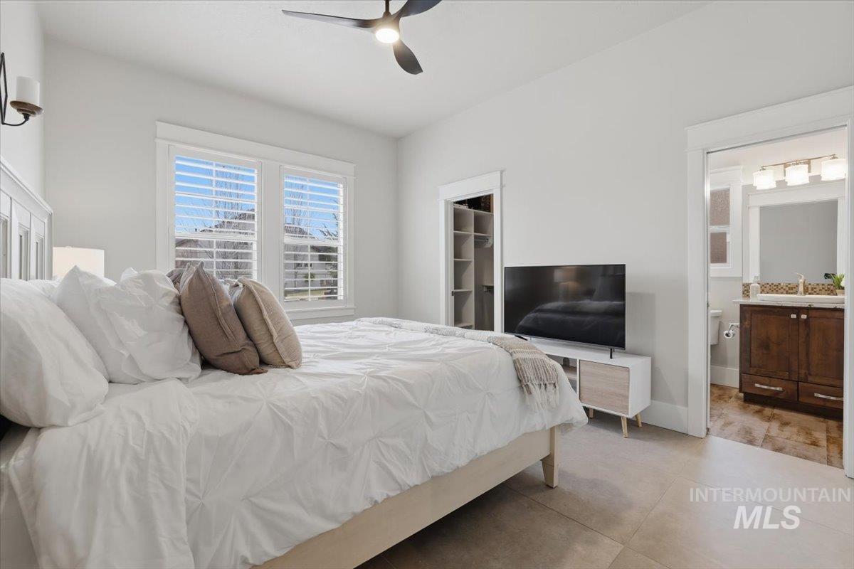 6590 North Fairborn Avenue Meridian, ID 83646 - Photo 41 of 49 Bedroom with a spacious closet, a ceiling fan, ensuite bath, and light tile patterned floors