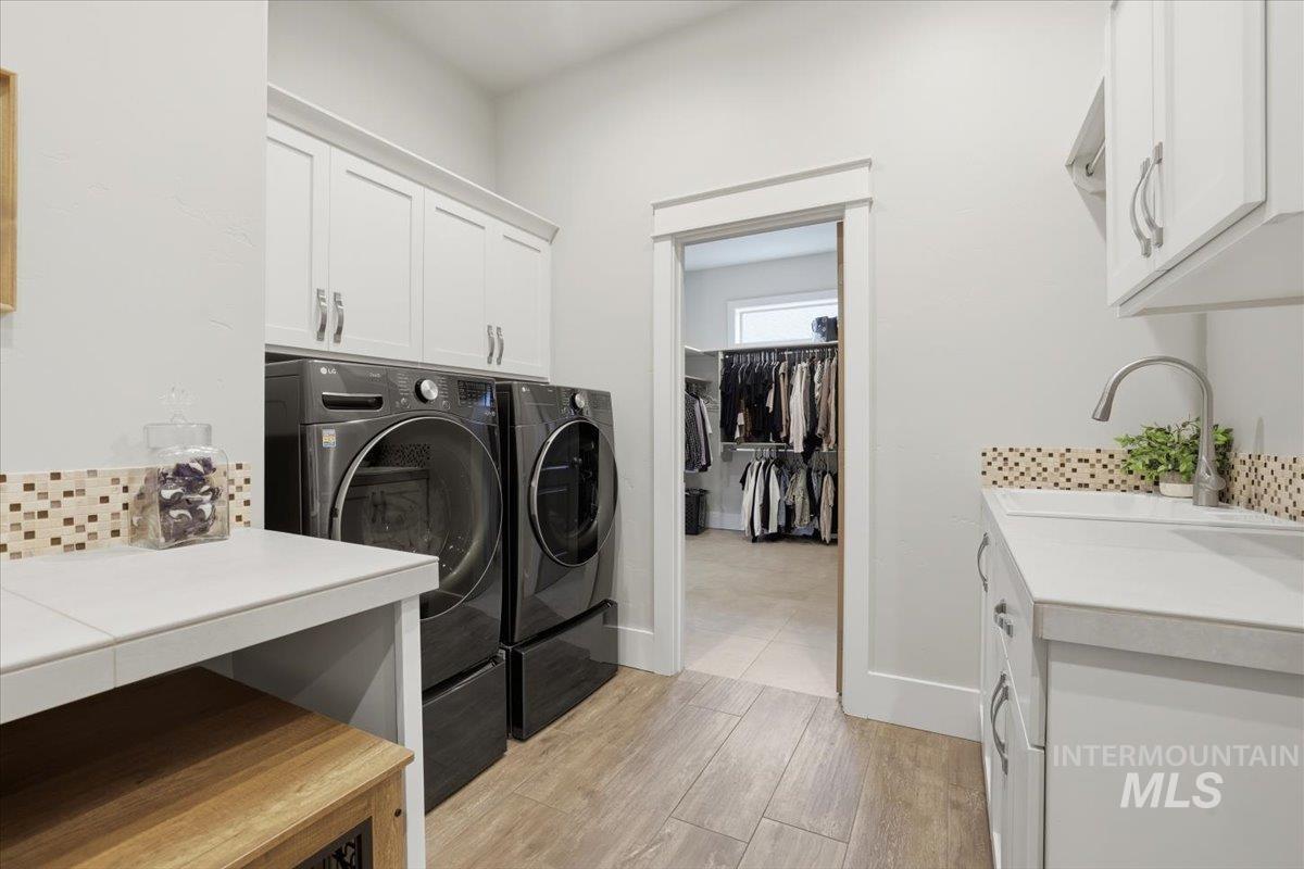 6590 North Fairborn Avenue Meridian, ID 83646 - Photo 42 of 49 Laundry room featuring cabinet space, light wood-style floors, and washer and dryer