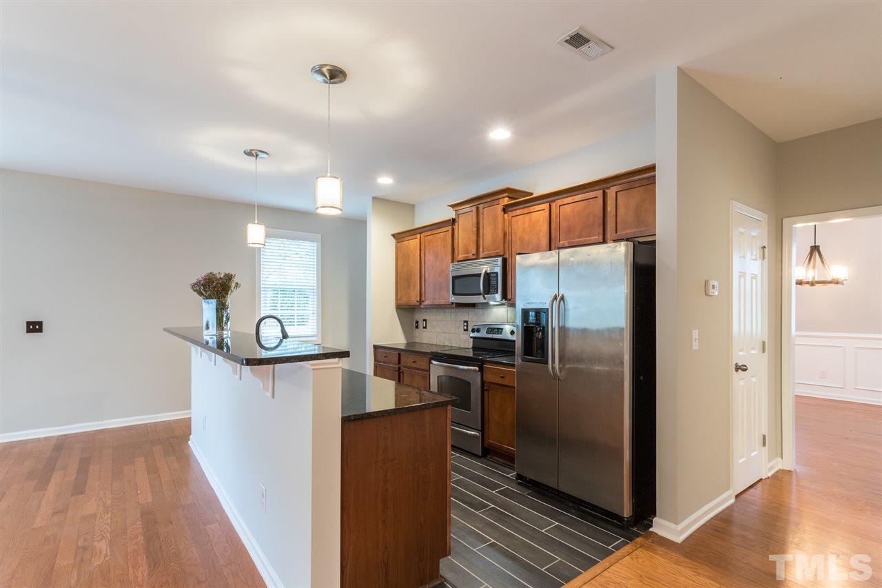 1354 Regulator Street Raleigh, NC 27603 - Photo 14 of 30 a kitchen with stainless steel appliances granite countertop a refrigerator and a sink