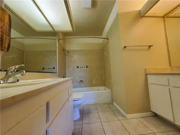 a bathroom with a granite countertop sink a toilet and shower