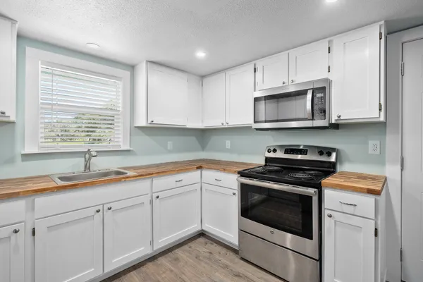 a kitchen with cabinets appliances a sink and a window