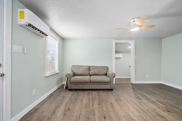 a living room with furniture and a wooden floor