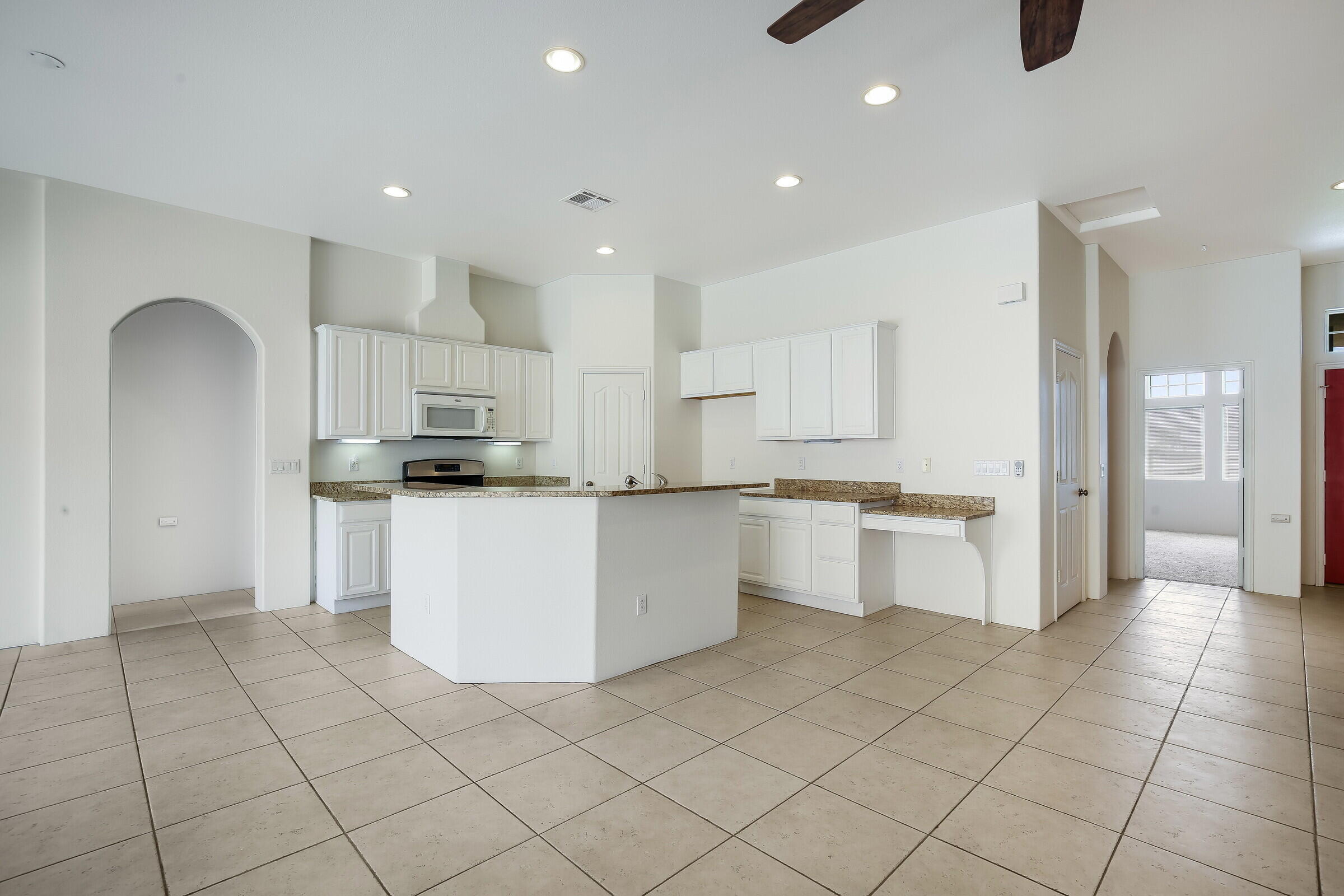 10748 Ocotillo Road Desert Hot Springs, CA 92240 - Photo 3 of 28 a kitchen with white cabinets and appliances