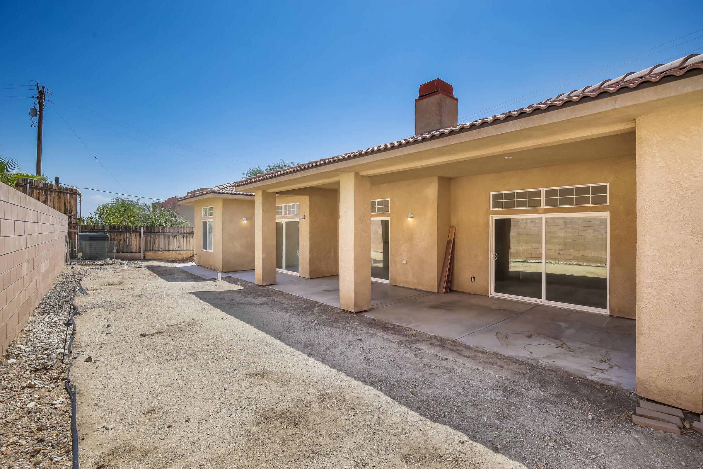 10748 Ocotillo Road Desert Hot Springs, CA 92240 - Photo 24 of 28 a view of a house with a backyard and balcony