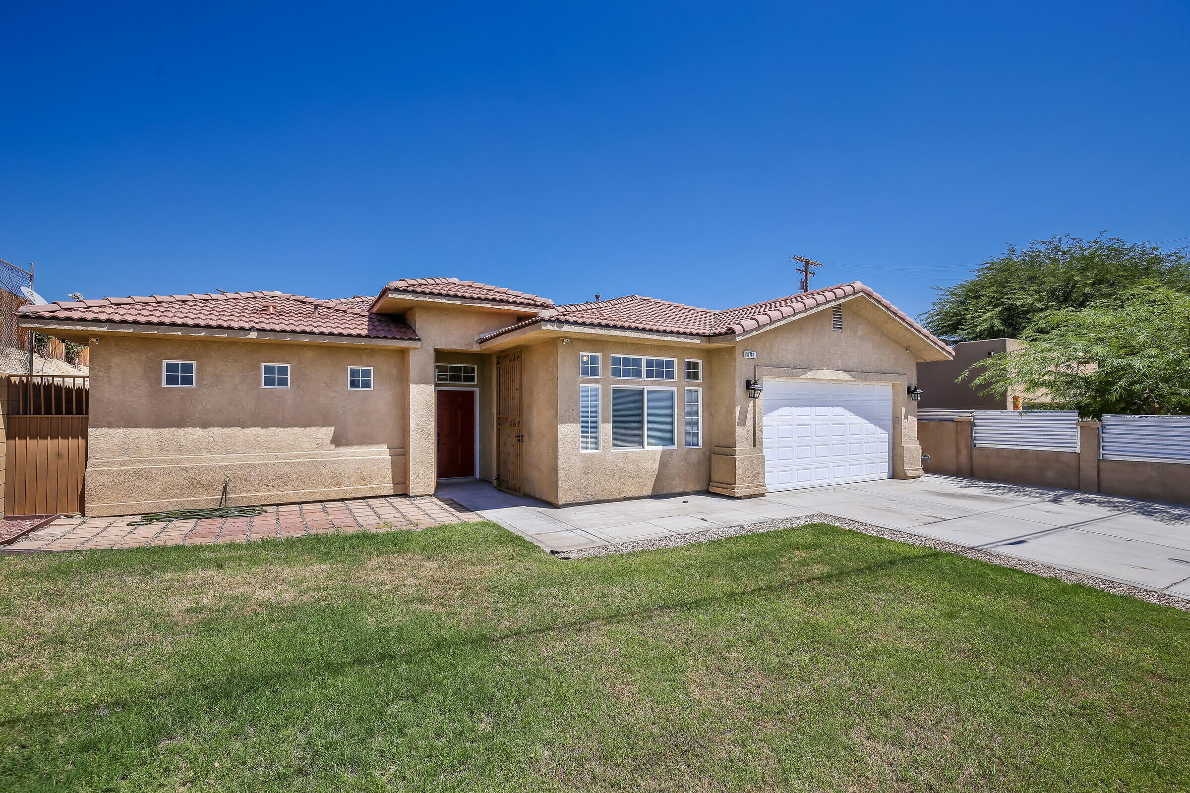 10748 Ocotillo Road Desert Hot Springs, CA 92240 - Photo 25 of 28 a front view of a house with a garden and yard