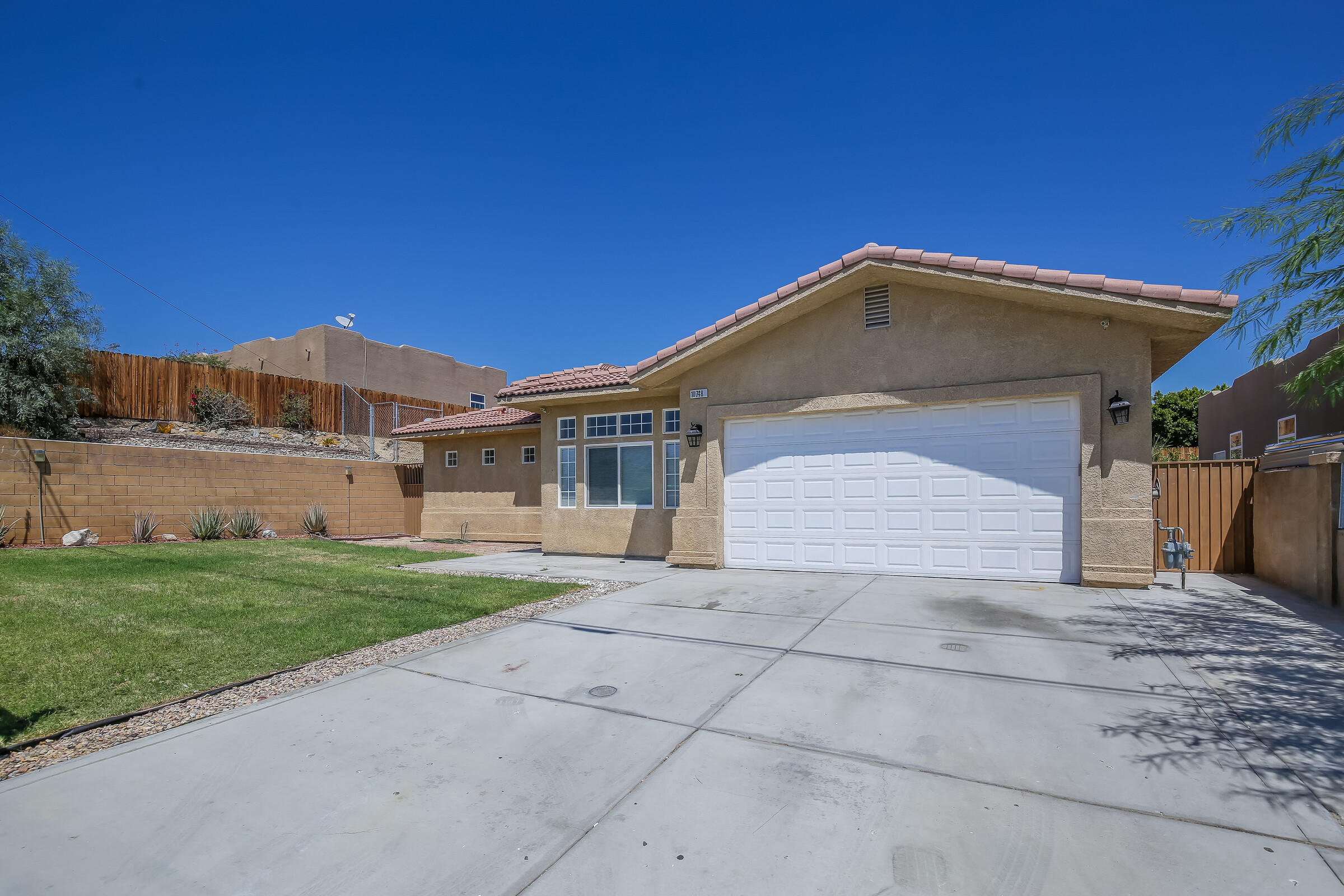 10748 Ocotillo Road Desert Hot Springs, CA 92240 - Photo 27 of 28 a front view of a house with a yard and garage