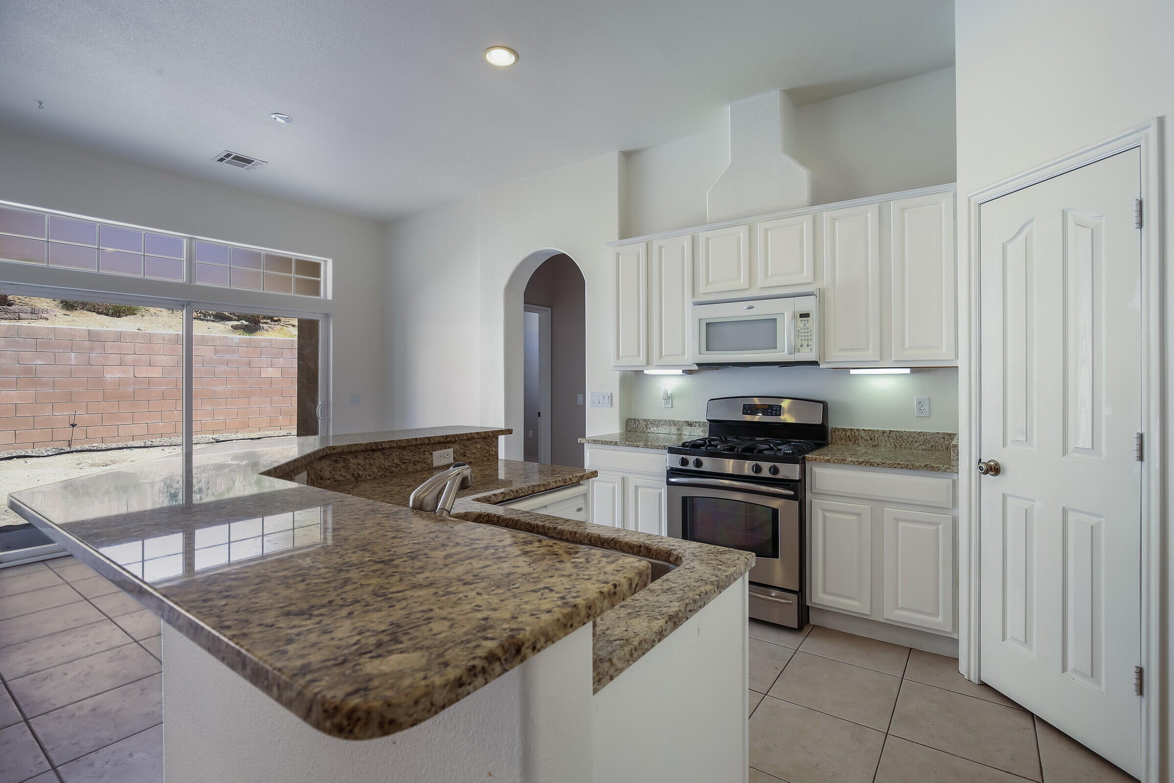 10748 Ocotillo Road Desert Hot Springs, CA 92240 - Photo 5 of 28 a kitchen with stainless steel appliances granite countertop a sink stove and refrigerator