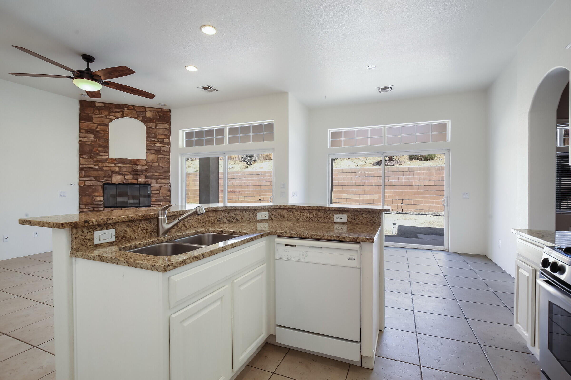 10748 Ocotillo Road Desert Hot Springs, CA 92240 - Photo 6 of 28 a kitchen with granite countertop a sink and a stove