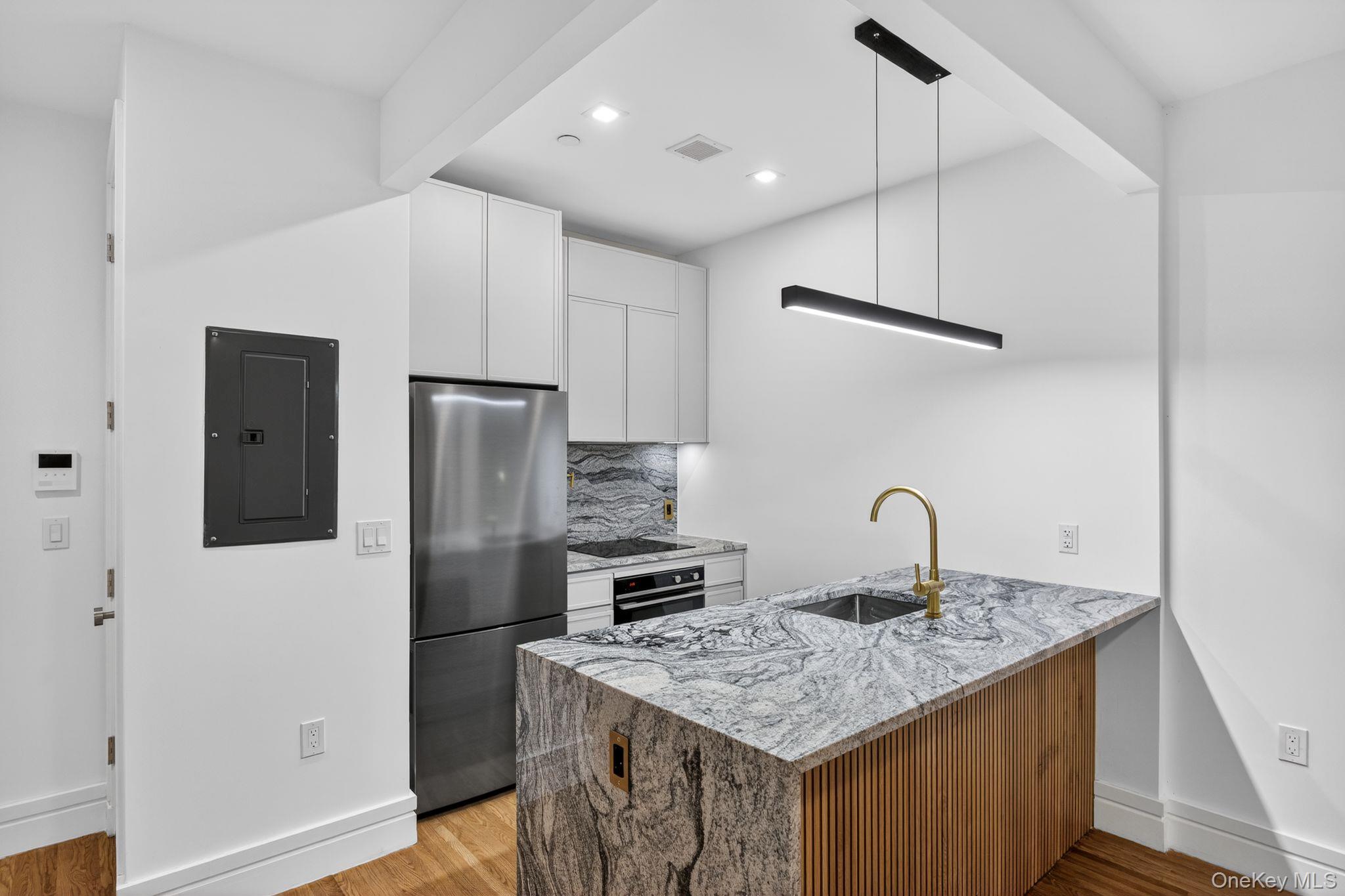60 West 129th Street, Unit 409 Manhattan, NY 10027 - Photo 3 of 17 a kitchen with stainless steel appliances granite countertop a refrigerator a sink and a stove
