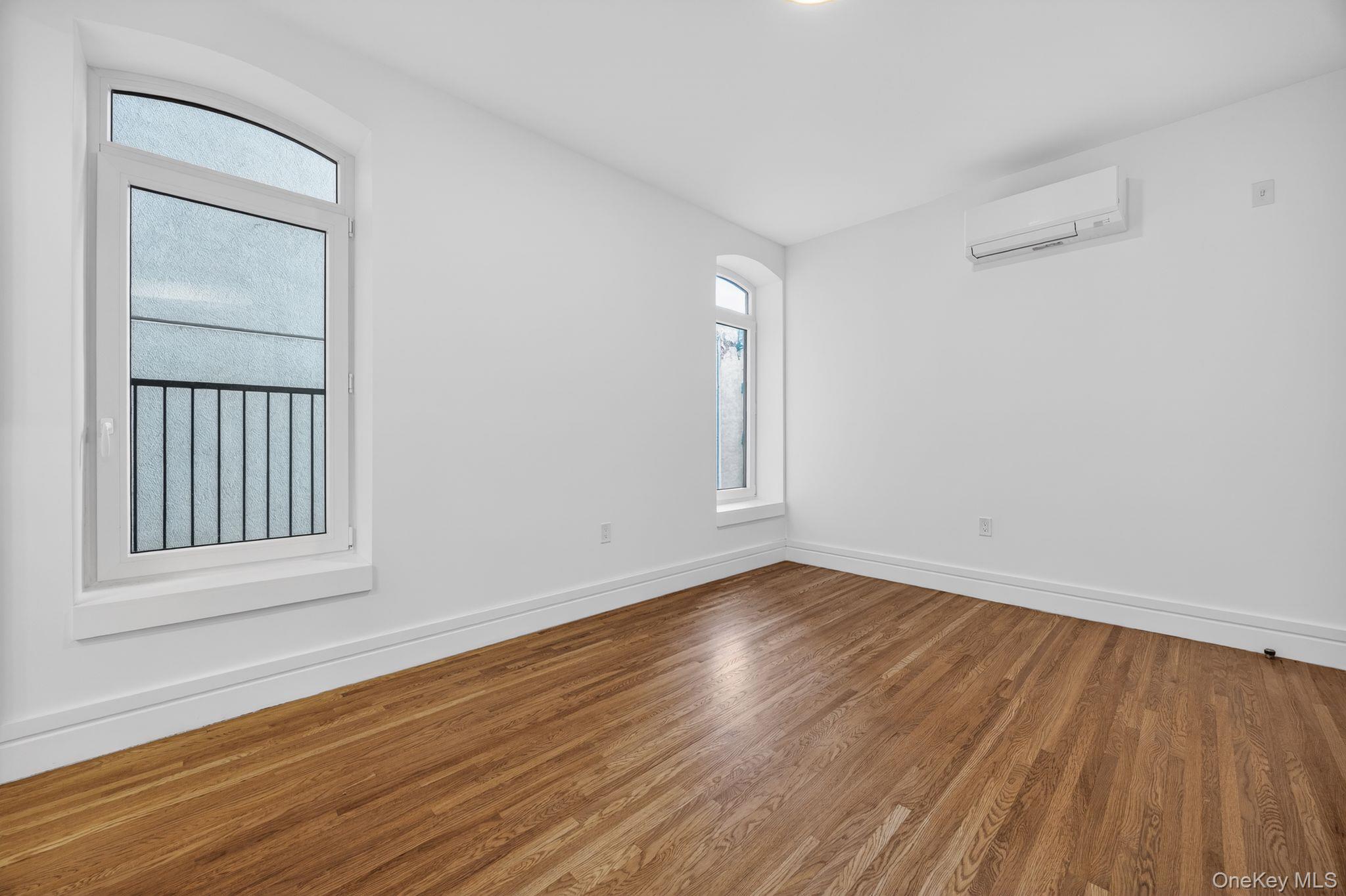 60 West 129th Street, Unit 409 Manhattan, NY 10027 - Photo 7 of 17 a view of an empty room with wooden floor and a window