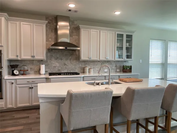 a kitchen with a table chairs sink and cabinets