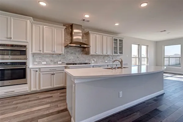 a kitchen with stainless steel appliances granite countertop a sink a stove and a refrigerator
