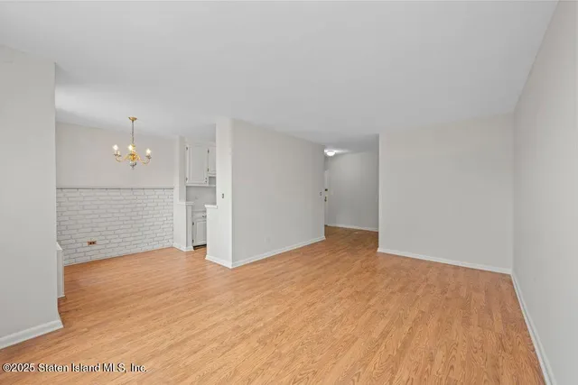 a view of a big room with wooden floor and windows