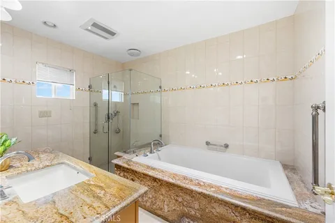 a bathroom with a granite countertop tub sink and shower