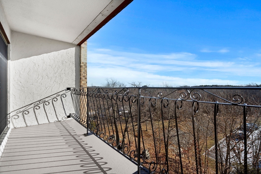 159 Franklin Street, Unit E6 Stoneham, MA 02180 - Photo 12 of 22 a view of a balcony with wooden floor and fence