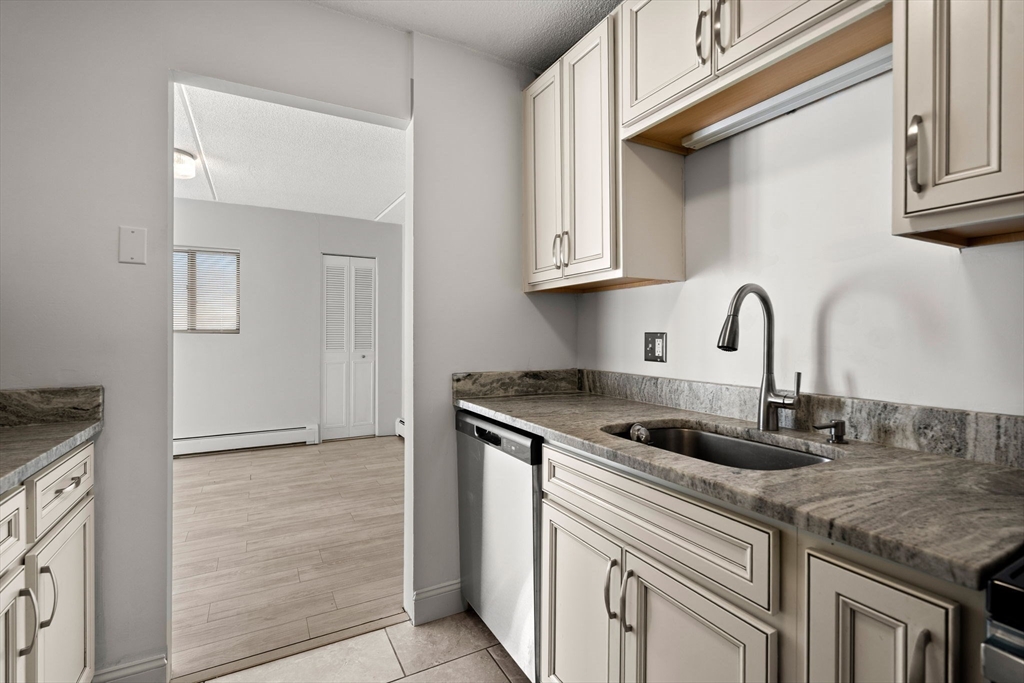 159 Franklin Street, Unit E6 Stoneham, MA 02180 - Photo 14 of 22 a kitchen with granite countertop a sink and cabinets