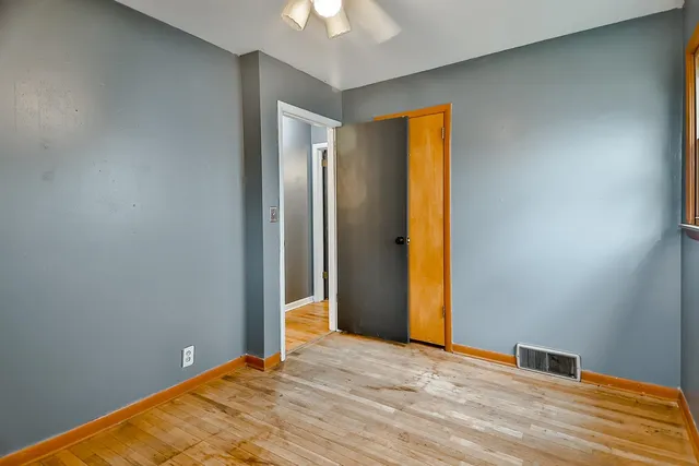 a view of empty room with window and ceiling fan