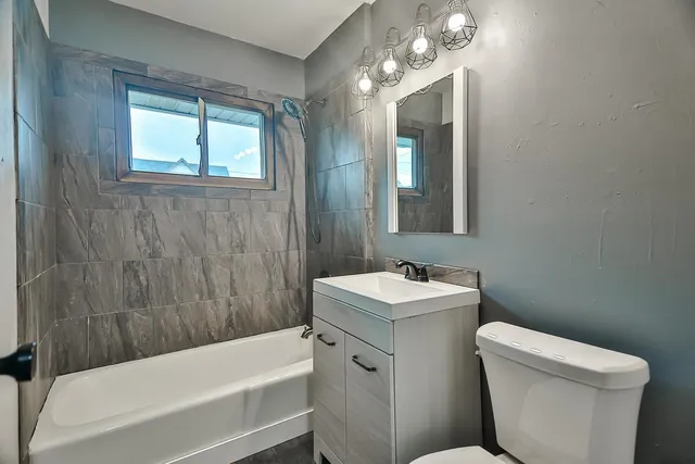 a bathroom with a sink a toilet a mirror and a bathtub