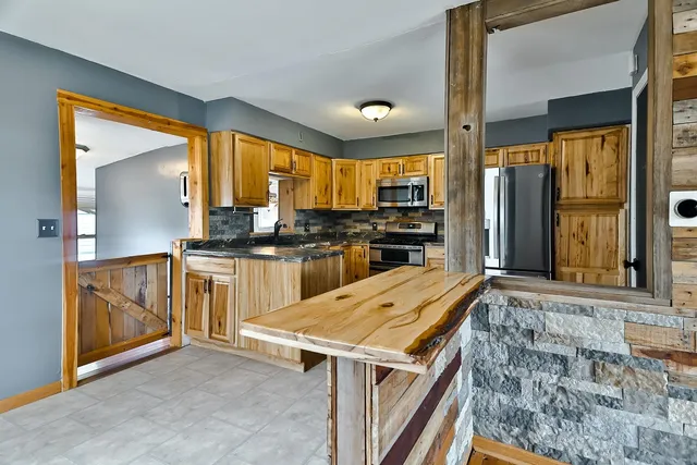 a kitchen with granite countertop a stove a sink and a refrigerator